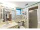 Cozy bathroom with a toilet, sink, mirror, and shower with patterned wallpaper at 4533 Marine Pkwy # 206, New Port Richey, FL 34652