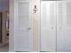 Hallway featuring doors, including closet doors and a bedroom door with a light fixture at 4533 Marine Pkwy # 206, New Port Richey, FL 34652