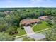 Aerial view showcasing the home's well-maintained landscaping and expansive driveway at 4603 Lake In The Woods Dr, Spring Hill, FL 34607