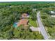 Stunning aerial view of a residential property featuring a pool, manicured lawn, and tree-lined streets at 4603 Lake In The Woods Dr, Spring Hill, FL 34607