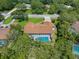 Aerial view of property featuring a screened-in pool, manicured lawn, and mature trees for backyard privacy at 4603 Lake In The Woods Dr, Spring Hill, FL 34607