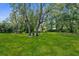 An expansive backyard with lush, well-maintained lawn and mature trees creating a private, serene outdoor space at 4603 Lake In The Woods Dr, Spring Hill, FL 34607