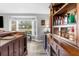 Bar area featuring a wooden bar with storage, a window with a view, and a beverage fridge at 4603 Lake In The Woods Dr, Spring Hill, FL 34607