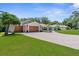 Charming home with a stone accent, three-car garage and a lush green lawn enhancing its curb appeal at 4603 Lake In The Woods Dr, Spring Hill, FL 34607
