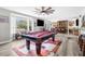 Spacious game room with a pool table, a large bay window, a bar area, and comfortable seating at 4603 Lake In The Woods Dr, Spring Hill, FL 34607