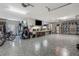 Spacious garage with speckled floor, work bench, storage racks and cabinets, ceiling fans, and a motorcycle at 4603 Lake In The Woods Dr, Spring Hill, FL 34607
