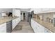 Open concept kitchen with stainless steel appliances, granite countertops, and white cabinets, offering ample storage at 4603 Lake In The Woods Dr, Spring Hill, FL 34607