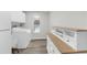 Bright laundry room with white cabinets, a washer and dryer, and wood grain floors at 4603 Lake In The Woods Dr, Spring Hill, FL 34607