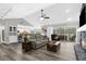 Open living area with a stone fireplace and views of the kitchen and screened pool area at 4603 Lake In The Woods Dr, Spring Hill, FL 34607