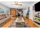 Living room with hardwood floors, a ceiling fan, and an oversized brown sofa at 4603 Lake In The Woods Dr, Spring Hill, FL 34607