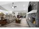 Living room showcasing a stone fireplace, comfortable seating, and access to a screened outdoor patio at 4603 Lake In The Woods Dr, Spring Hill, FL 34607