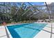Large outdoor swimming pool in screened-in lanai with lounge chairs at 4603 Lake In The Woods Dr, Spring Hill, FL 34607