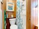 Bathroom featuring a white toilet, tiled shower, and wooden paneling at 4929 N River Shore Dr # A, Tampa, FL 33603