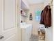 Bright laundry room with white washer and dryer, storage shelf, window and coat rack at 4929 N River Shore Dr # A, Tampa, FL 33603