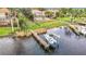 Dock leading to waterfront featuring a boat lift and well-manicured lawn in the backyard at 4929 N River Shore Dr # A, Tampa, FL 33603