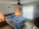 Bedroom with ceiling fan, tile floors, full size bed and a lace curtained window at 8150 Braddock Cir # 4, Port Richey, FL 34668