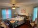 Cozy bedroom featuring a queen bed with a floral comforter and matching curtains at 8150 Braddock Cir # 4, Port Richey, FL 34668