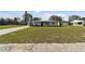 Well-maintained single-story home with a lush green lawn and a long driveway at 980 Sunrise Dr, Tarpon Springs, FL 34689