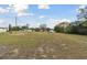 View of a grassy and expansive plot of land ready for building with scattered trees under a partially cloudy sky at 980 Sunrise Dr, Tarpon Springs, FL 34689