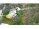 Aerial view of the house with in ground screened pool and lush surroundings at 1031 Pomme De Pin Ln, New Port Richey, FL 34655
