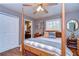 Comfortable bedroom featuring a ceiling fan, wood floors, and natural light from the large window at 1031 Pomme De Pin Ln, New Port Richey, FL 34655