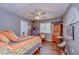 Well-lit bedroom with wood floors, ceiling fan, and closet offers comfort and ample storage at 1031 Pomme De Pin Ln, New Port Richey, FL 34655