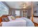 Bedroom featuring a ceiling fan, wooden accents, and natural light from the large window at 1031 Pomme De Pin Ln, New Port Richey, FL 34655