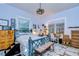 Inviting bedroom with a vintage bed frame, eclectic decor, and ample natural light at 1031 Pomme De Pin Ln, New Port Richey, FL 34655