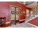 Warm entryway with wood floors, staircase, and view of the decorative front doors at 1031 Pomme De Pin Ln, New Port Richey, FL 34655