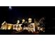 Charming home at night featuring dormer windows, lovely landscaping, and a welcoming front porch at 1031 Pomme De Pin Ln, New Port Richey, FL 34655