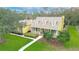 Aerial view of a well-manicured home featuring a classic yellow facade, complemented by verdant lawns at 1031 Pomme De Pin Ln, New Port Richey, FL 34655