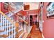 Grand foyer featuring a striking staircase, warm wood floors, and eclectic artwork for a unique entrance at 1031 Pomme De Pin Ln, New Port Richey, FL 34655