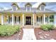 Welcoming front porch featuring decorative flags, wreaths and charming home decor at 1031 Pomme De Pin Ln, New Port Richey, FL 34655