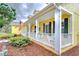 This inviting front porch features white railing, cozy seating, and manicured shrubbery at 1031 Pomme De Pin Ln, New Port Richey, FL 34655