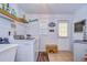 Functional laundry room with modern washer/dryer, open shelving, and easy access to the outdoors at 1031 Pomme De Pin Ln, New Port Richey, FL 34655