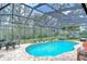 Screened in pool with patio furniture and lush landscaping at 1031 Pomme De Pin Ln, New Port Richey, FL 34655