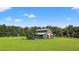 Exterior view of the charming blue two-story home with covered patio, set on a sprawling lawn at 11151 Lu Wista Ln, Brooksville, FL 34601