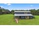 Attractive two-story home with a metal roof, a spacious green yard, and ample parking at 11151 Lu Wista Ln, Brooksville, FL 34601