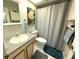 Standard bathroom with a single sink vanity, toilet, shower and coastal-themed decor at 11737 Spring Tree Ln, Port Richey, FL 34668