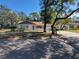 Single-story home with attached garage, mature shade trees and a well manicured front lawn at 12702 Whisper Cir, Hudson, FL 34667