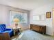 Bright living room with large window, blue chair, and wooden dresser at 12702 Whisper Cir, Hudson, FL 34667