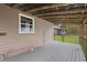 Covered back porch features wooded views and fenced yard; home exterior in view at 13289 Joy Path, Brooksville, FL 34601