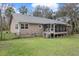 Well-maintained backyard with lush grass, mature trees, and screened-in porch at 13289 Joy Path, Brooksville, FL 34601