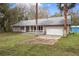 View of this single Gathering home featuring an attached garage, well manicured lawn and mature palm trees at 13289 Joy Path, Brooksville, FL 34601