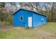 This is an exterior shot of the blue outbuilding featuring a window air conditioning unit at 13289 Joy Path, Brooksville, FL 34601