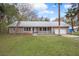 Charming single-story home featuring a welcoming front porch, attached garage and mature landscaping at 13289 Joy Path, Brooksville, FL 34601