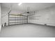 Spacious garage with white walls and ceiling, storage shelves, and a large paneled garage door at 13289 Joy Path, Brooksville, FL 34601