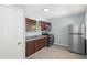 Compact kitchen with stainless steel appliances, brown cabinets, and a window at 13289 Joy Path, Brooksville, FL 34601