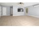 Open living room featuring neutral tile, ceiling fan, and access to the kitchen at 13289 Joy Path, Brooksville, FL 34601