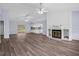 Spacious living room featuring wood-look floors, a fireplace and ceiling fan at 13289 Joy Path, Brooksville, FL 34601